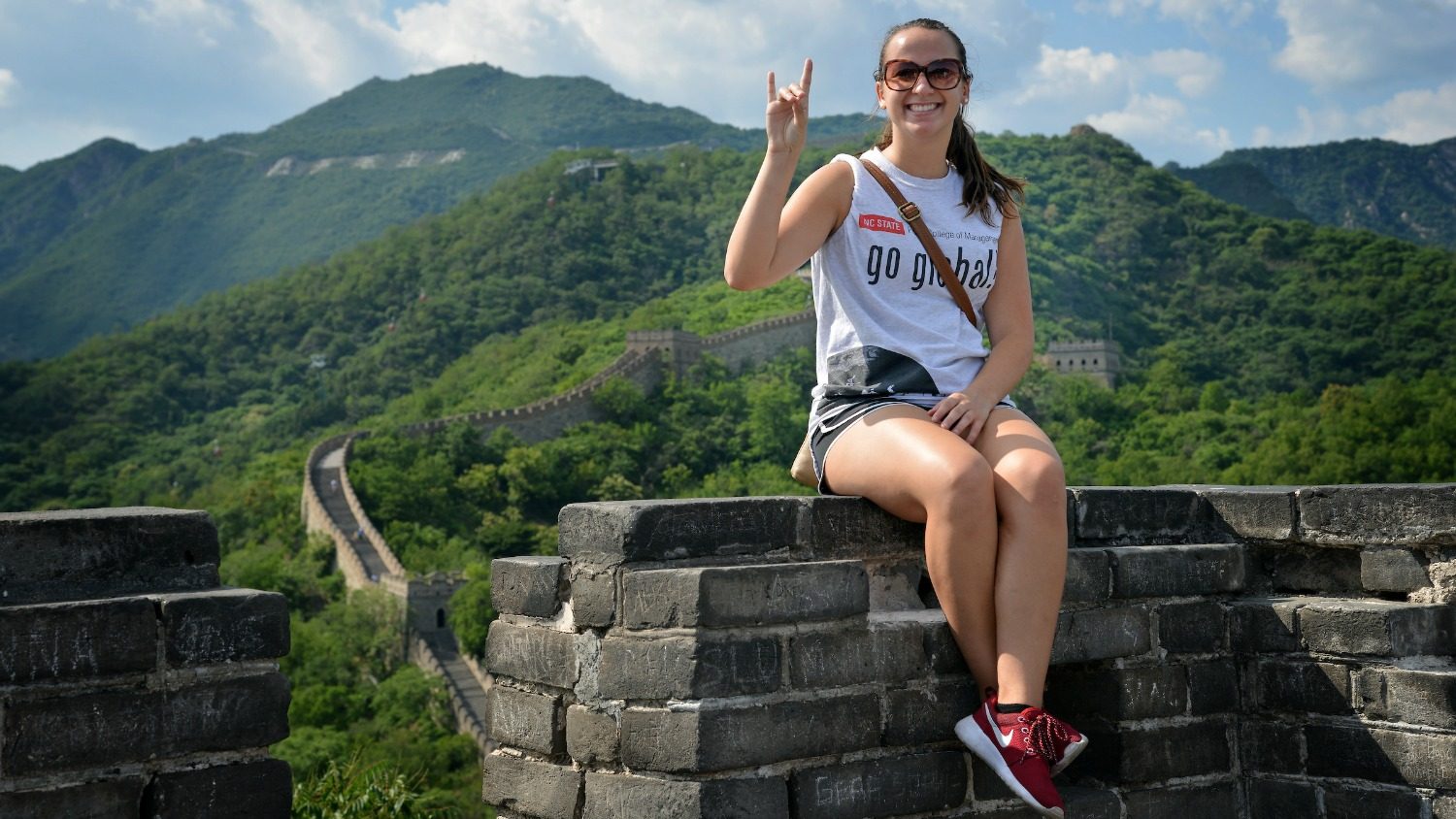Study abroad student on top of Great Wall in China.