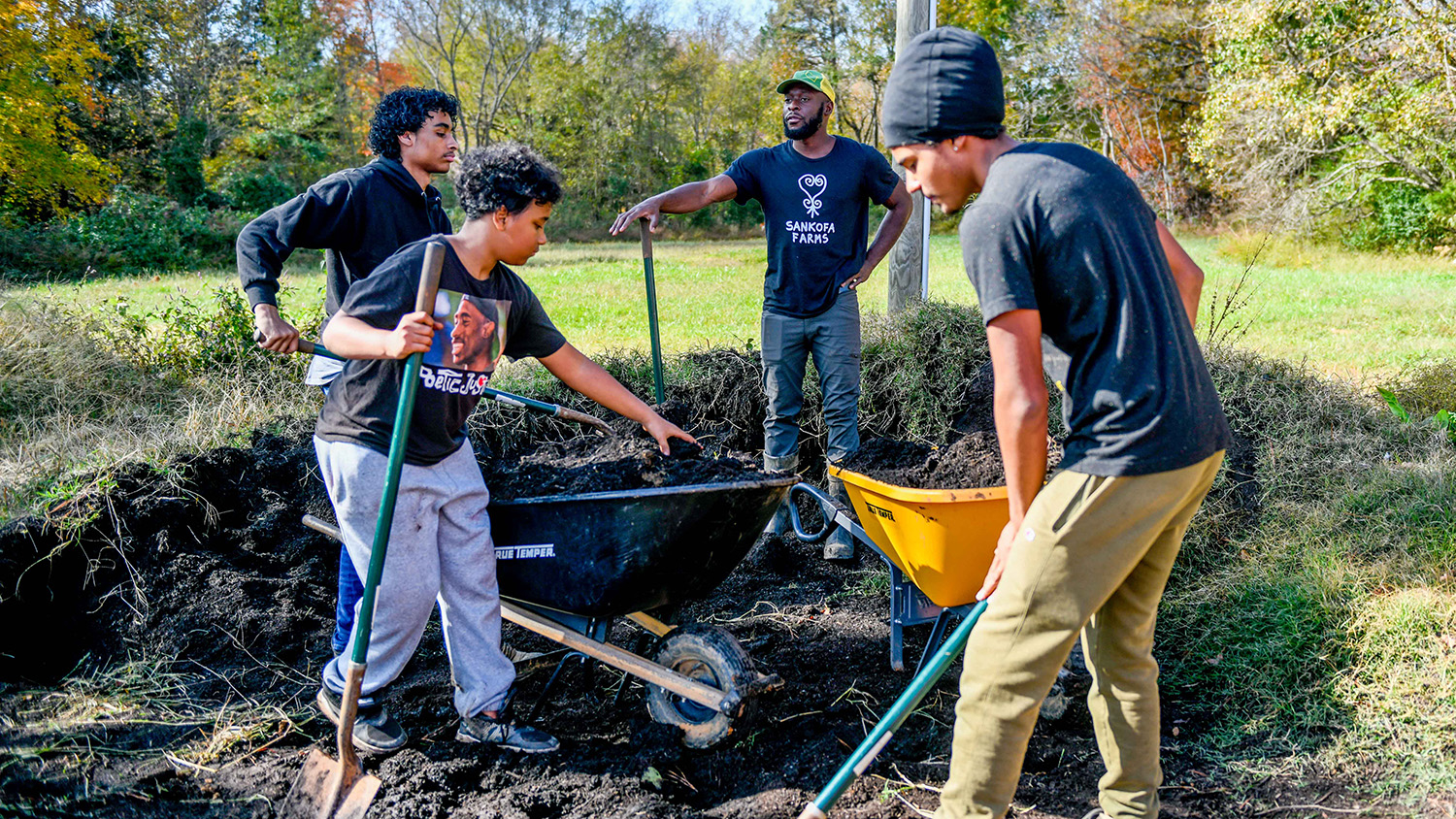 Young men digging and filling a wheelbarrow