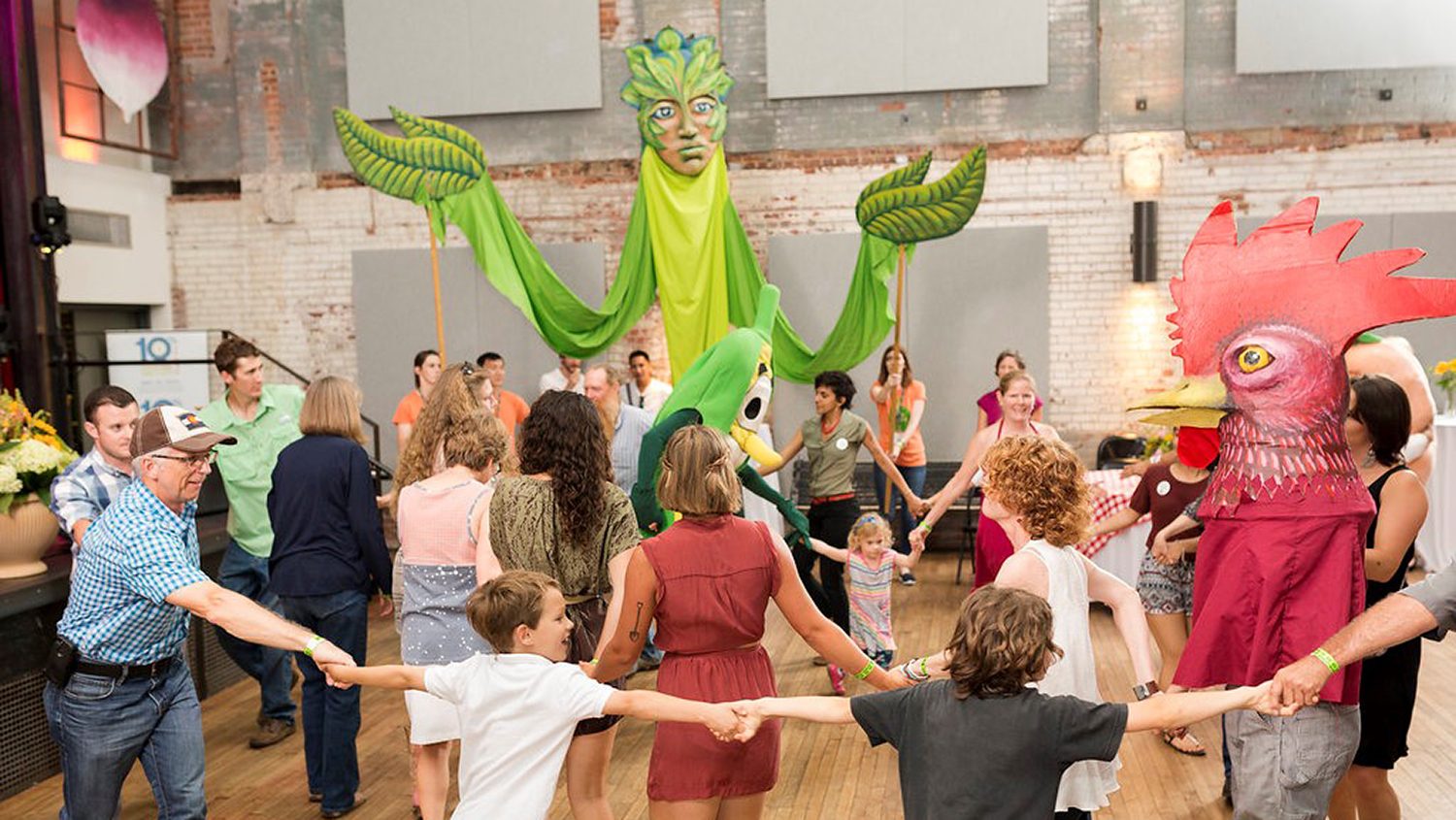 Kids and parents dance with puppets at Farm to Fork event