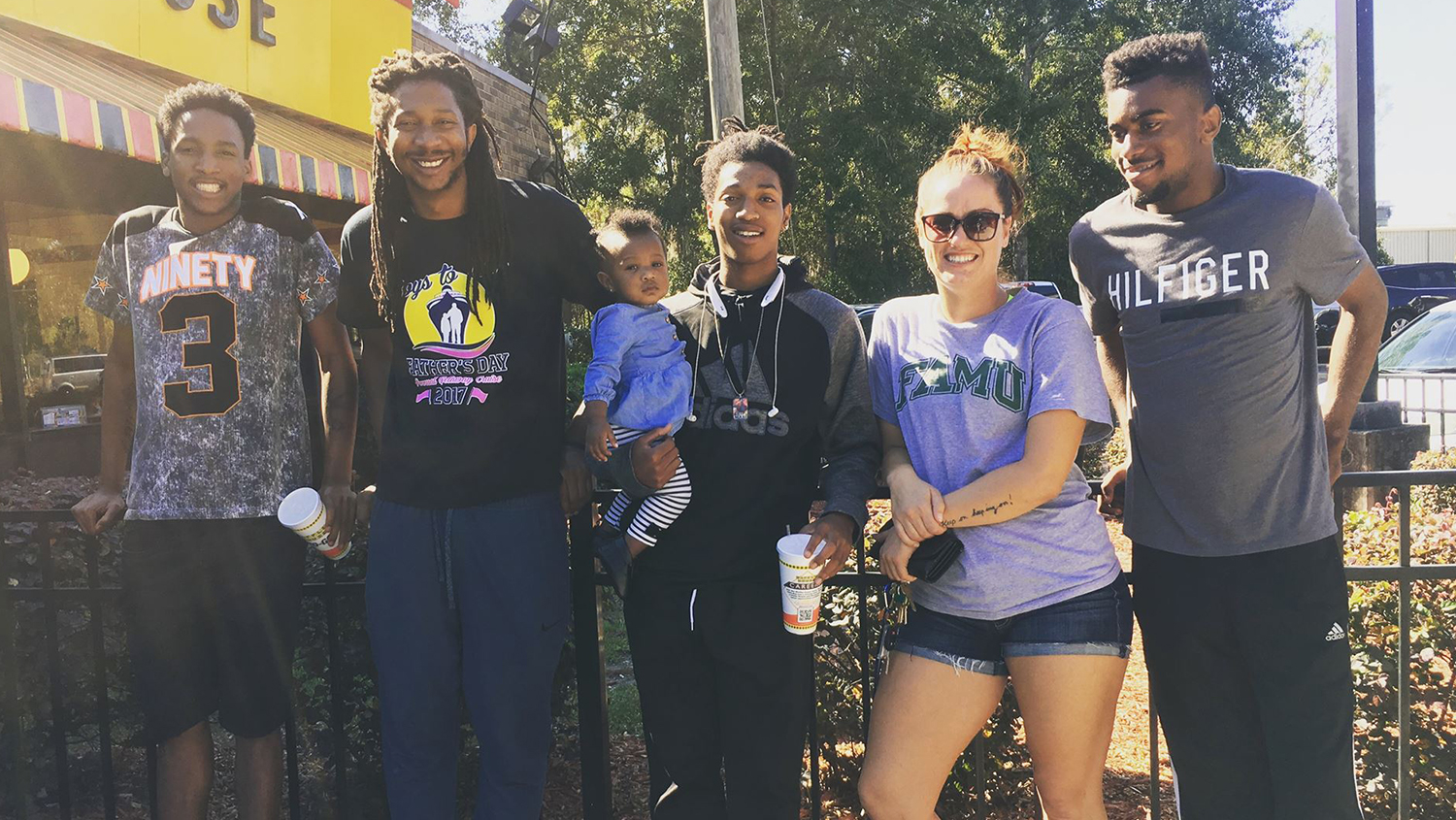Kendra Dowen is pictured with four students. One student is holding a child.