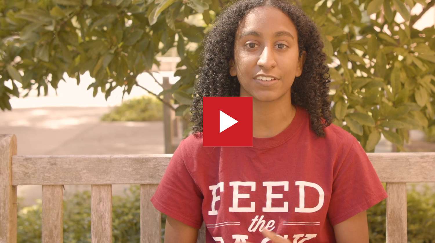 video still of a student in a Feed the Pack food pantry tee shirt