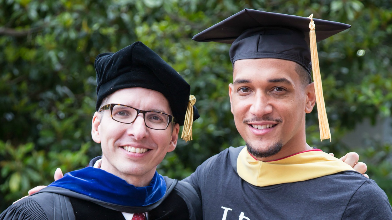 Student with graduate advisor at graduation.