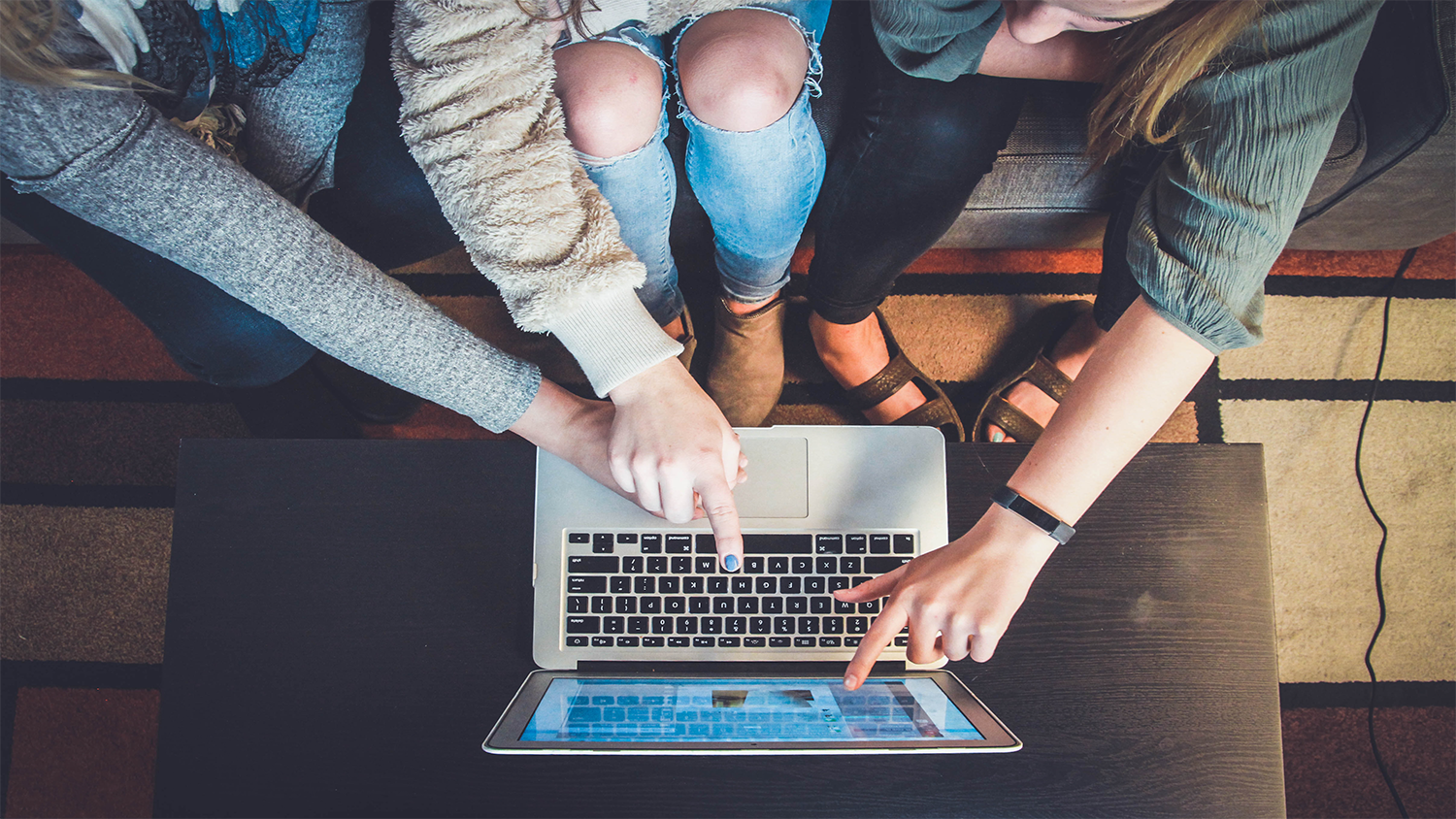 People pointing at computer screen