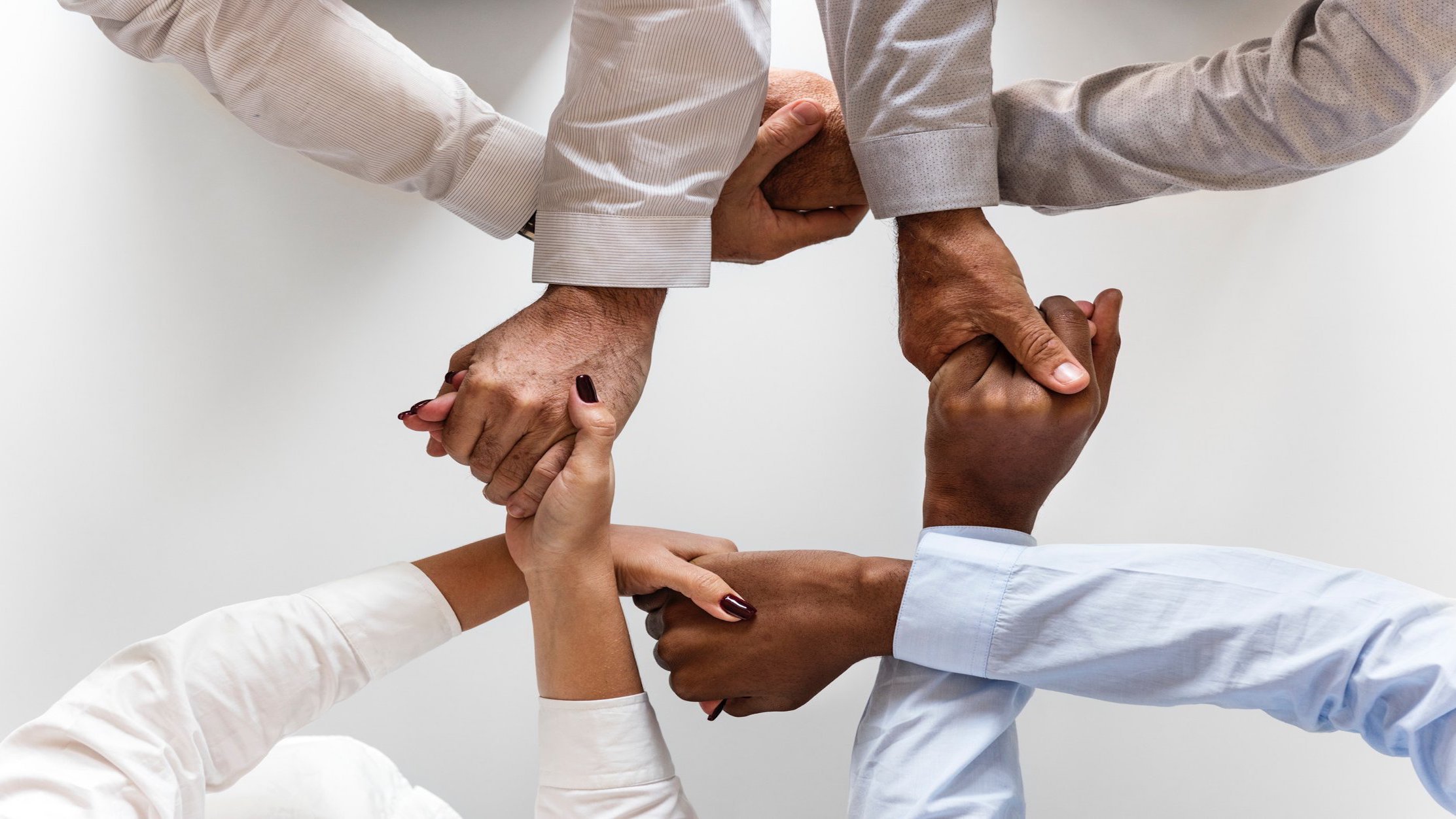 Various people linking hands