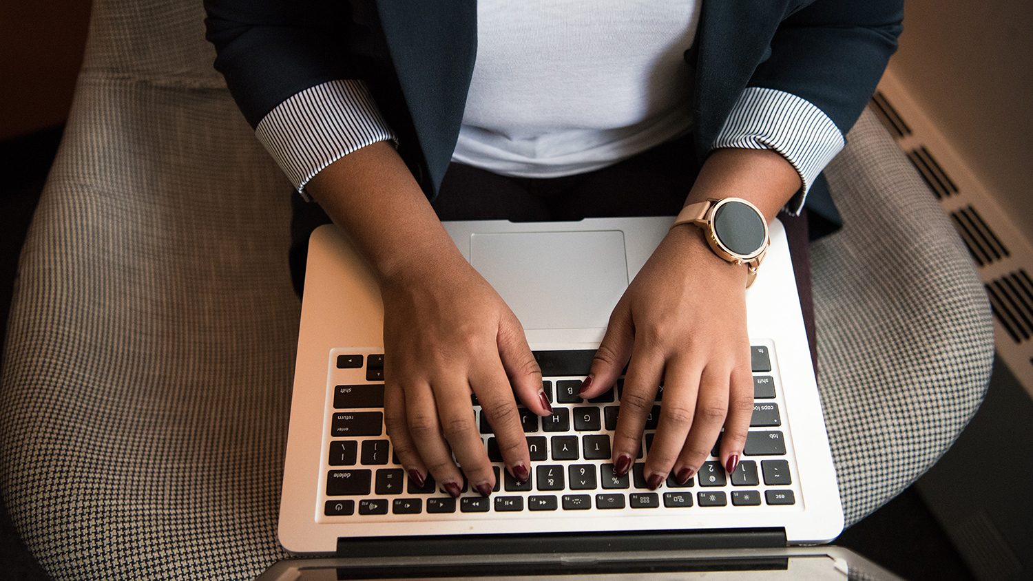 Hands typing on a laptop