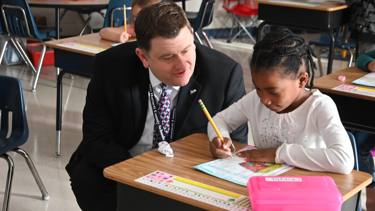 Harnett County Schools Superintendent Aaron Fleming helps Student child