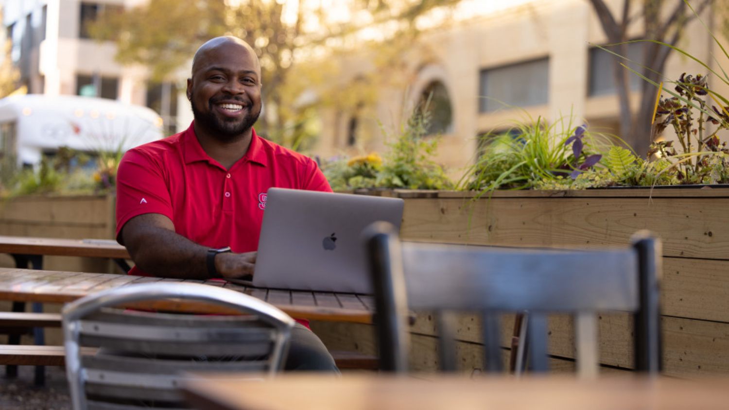 Keonte Edmons smiling at a table with a laptop