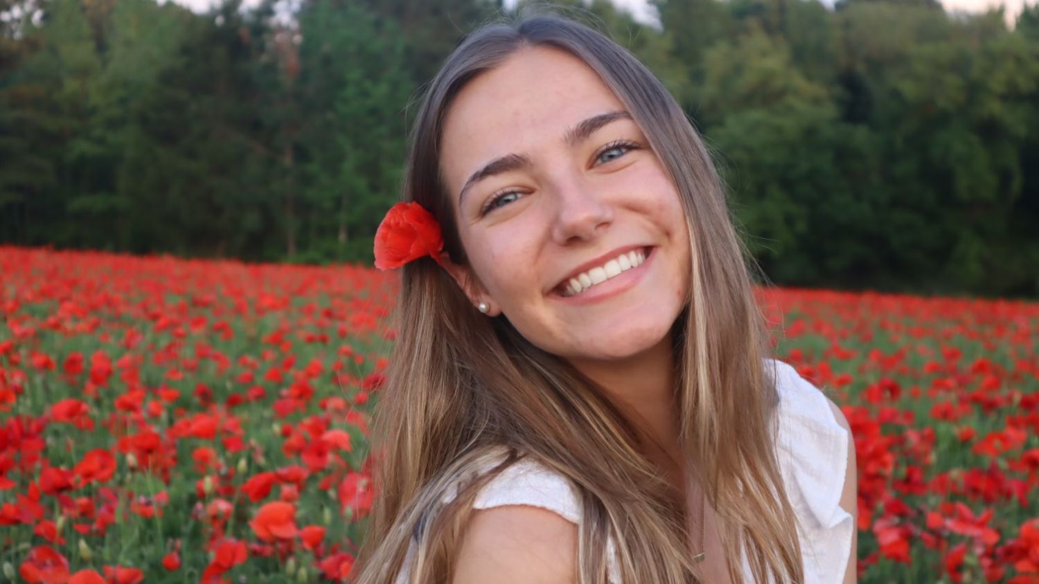 Sarah Grace in a field of flowers smiling