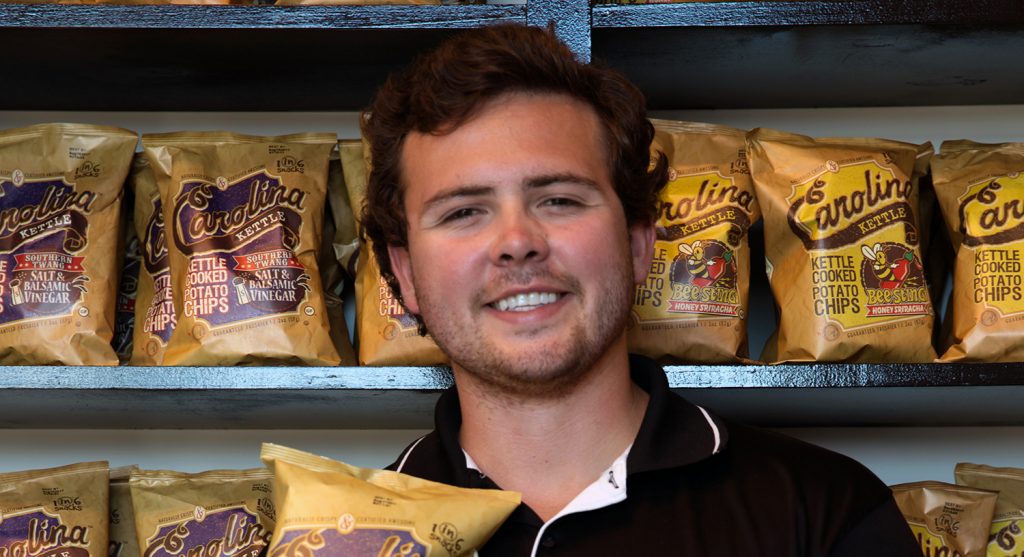 Josh Monahan standing in front of shelves of chip bags