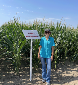 Woman stands next to PRECEON Smart Corn sign
