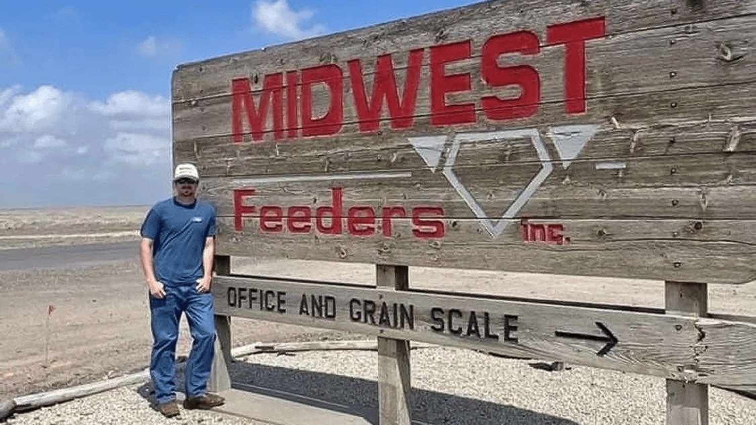 man standing in front of "Midwest" sign