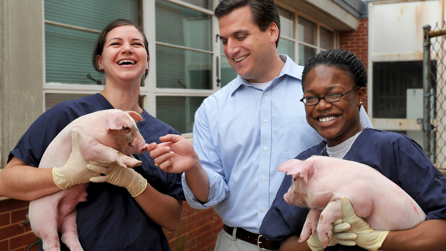 Animal Science teacher with students and piglets at NC State's Agricultural Institute