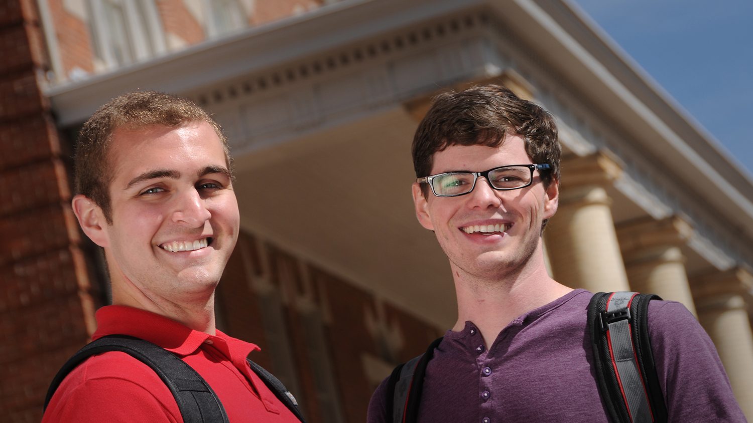 two male students standing in front of a campus building