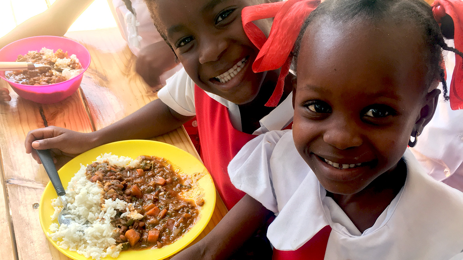 Haitian children eating lunch via the NCSU Haiti Goat Project