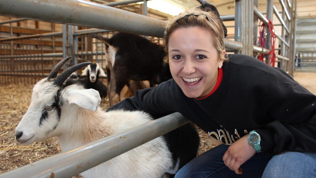 Smiling student with goat