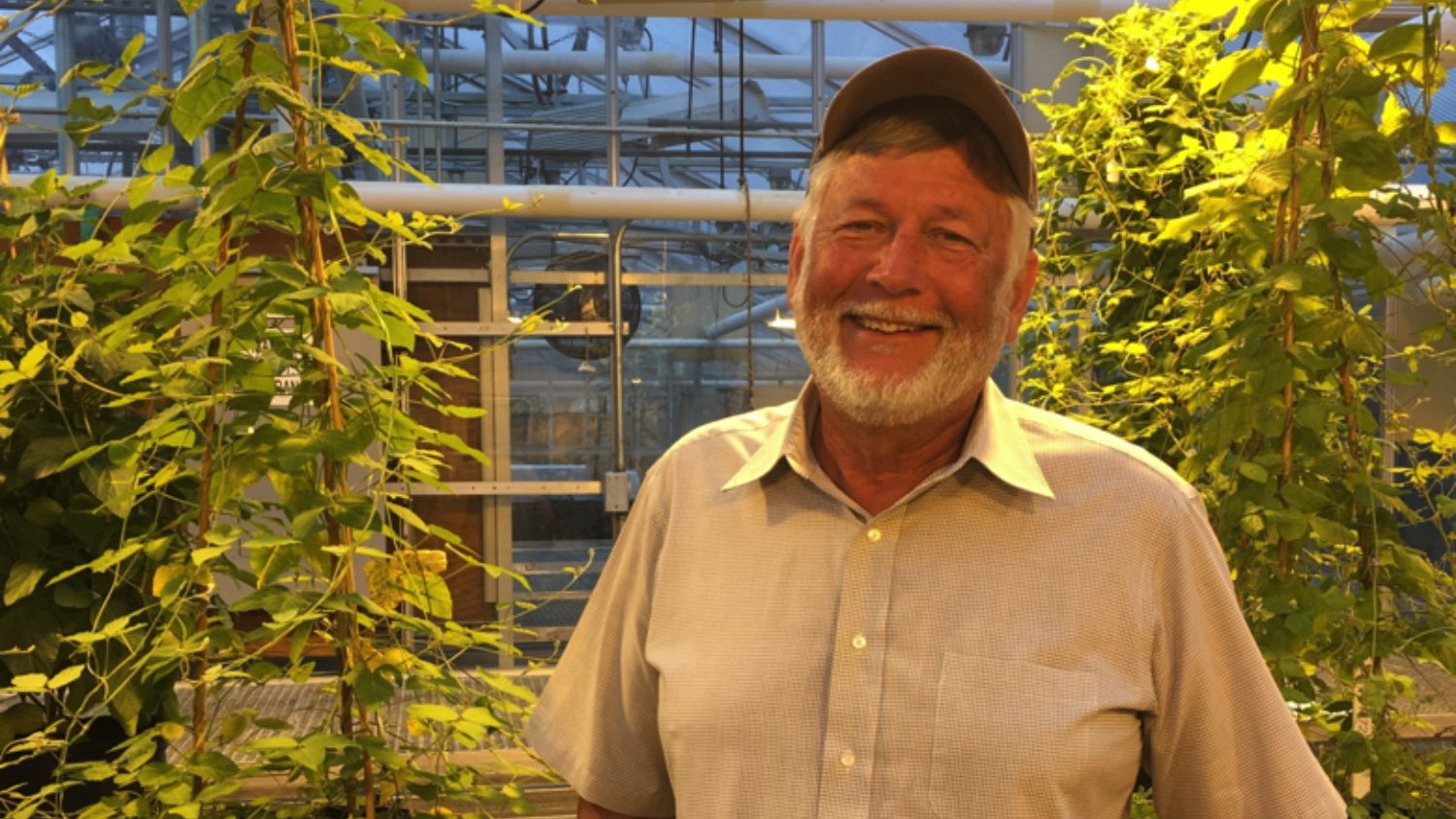 Tommy Carter, smiling, in a campus greenhouse.