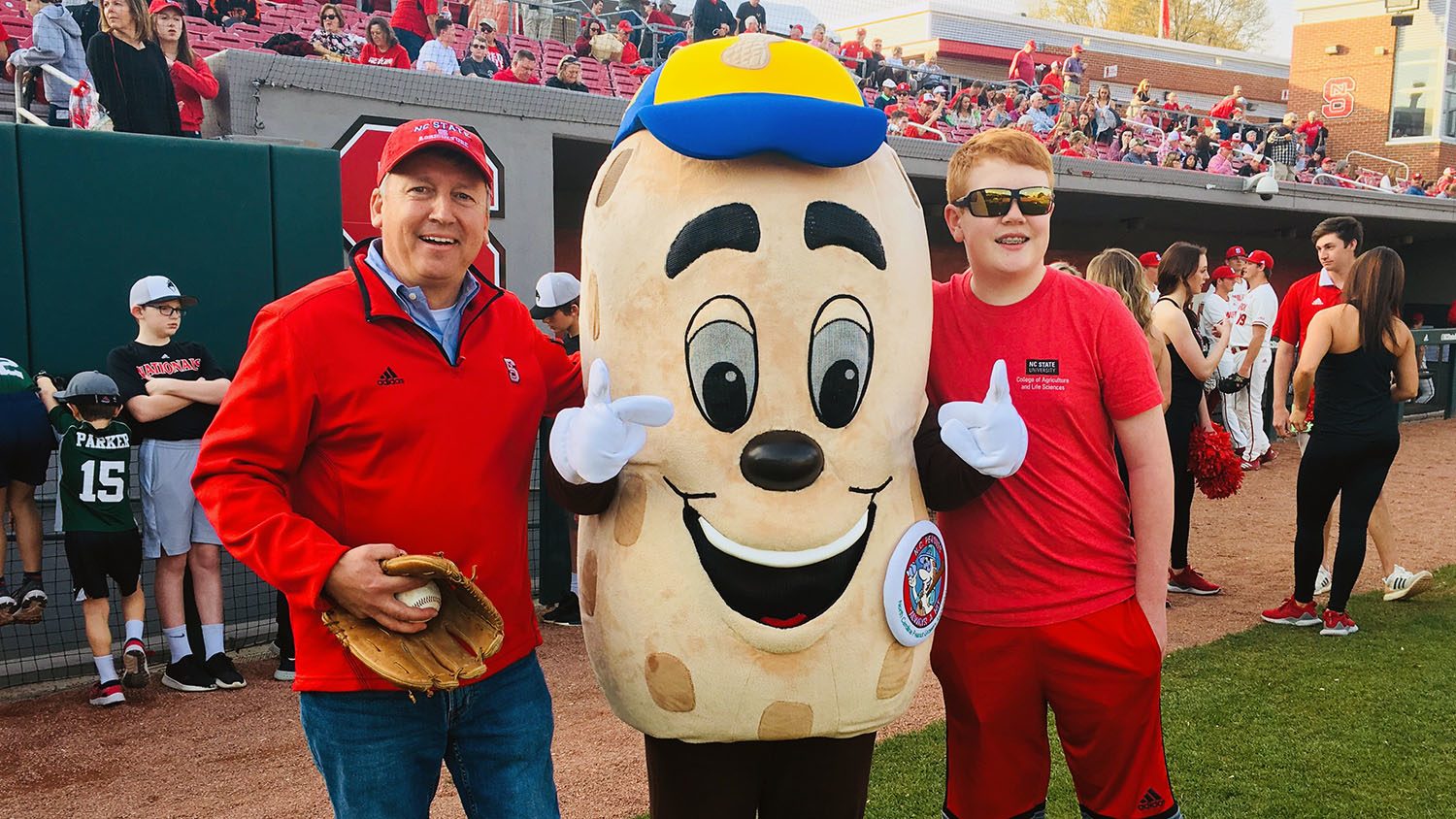 CALS Dean Richard Linton stands with a sports mascot with his son at a baseball game for Father's Day