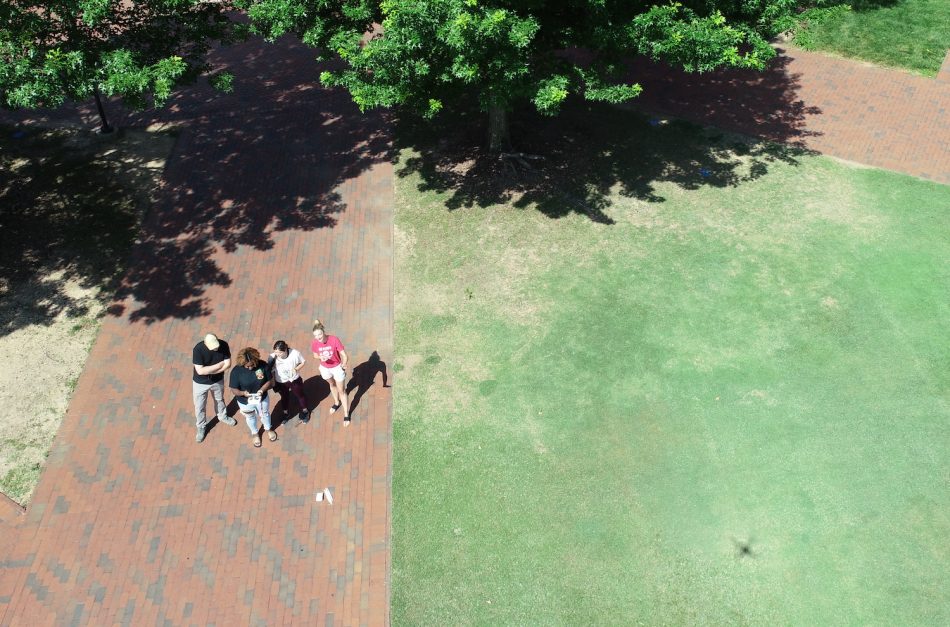 An aerial photo from a drone of the group standing on bricks.
