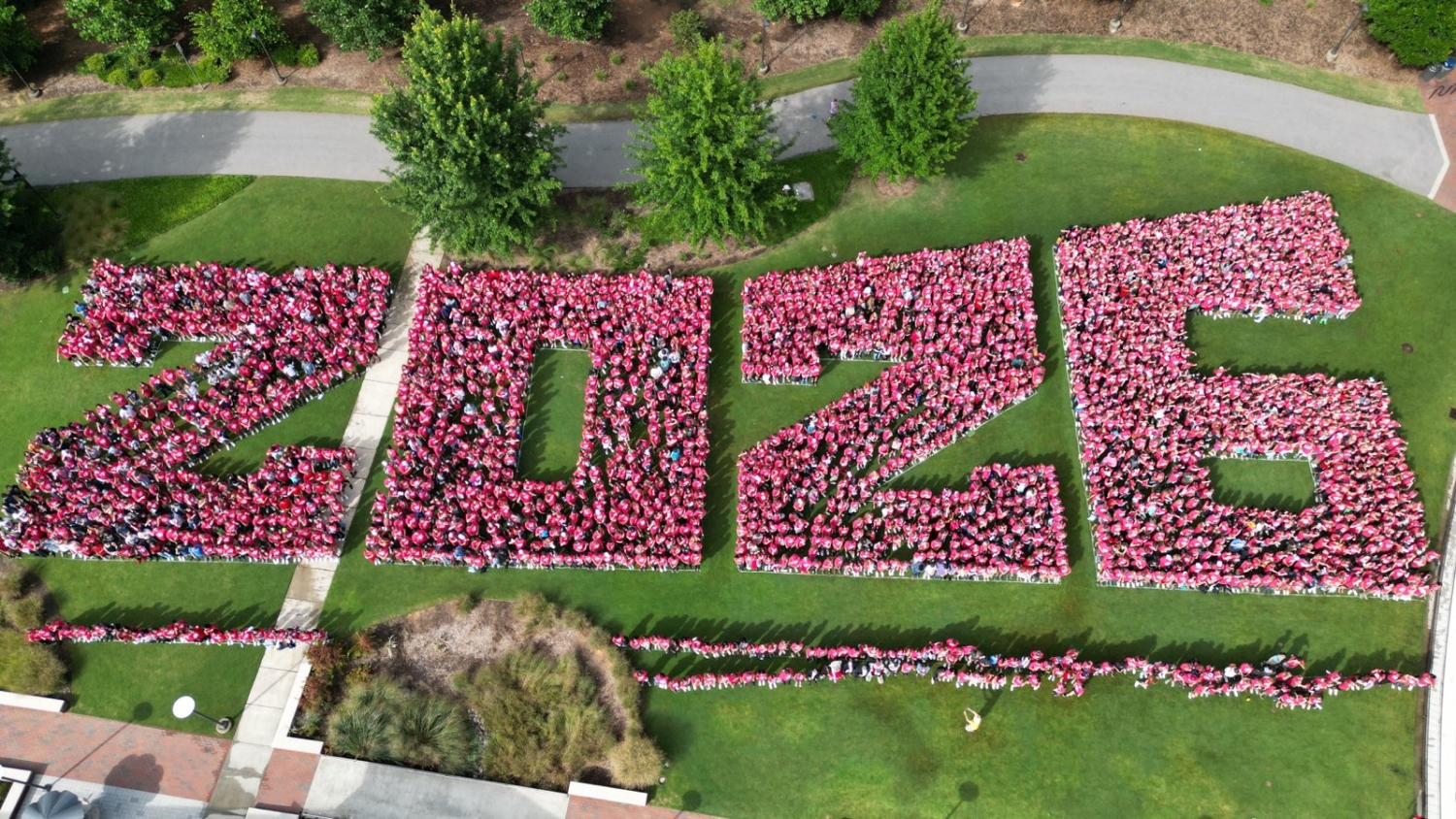 2026 spelled out by people wearing red on the lawn of Stafford Commons