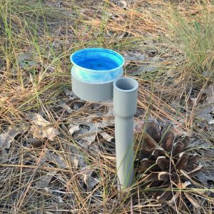 A brightly colored bowl of soapy water staked into the ground.