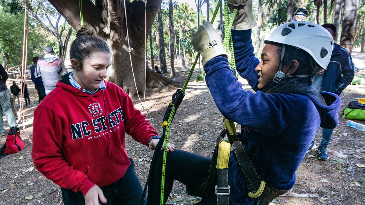 Michelle Kirchner (left) assists a friend while tree climbing in Madagascar.