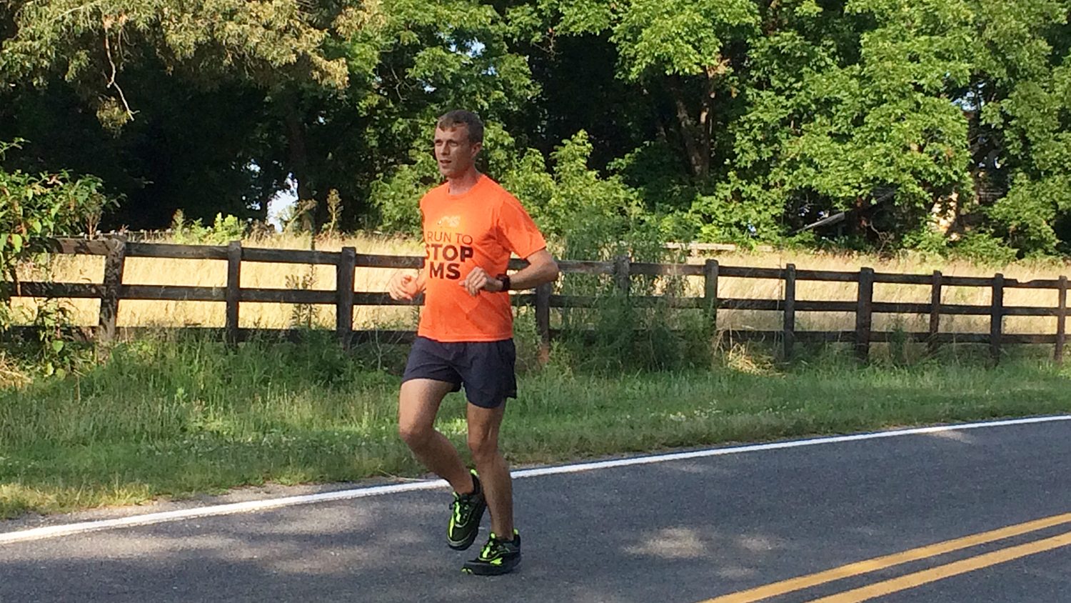 Robert Moore running along a shaded road.