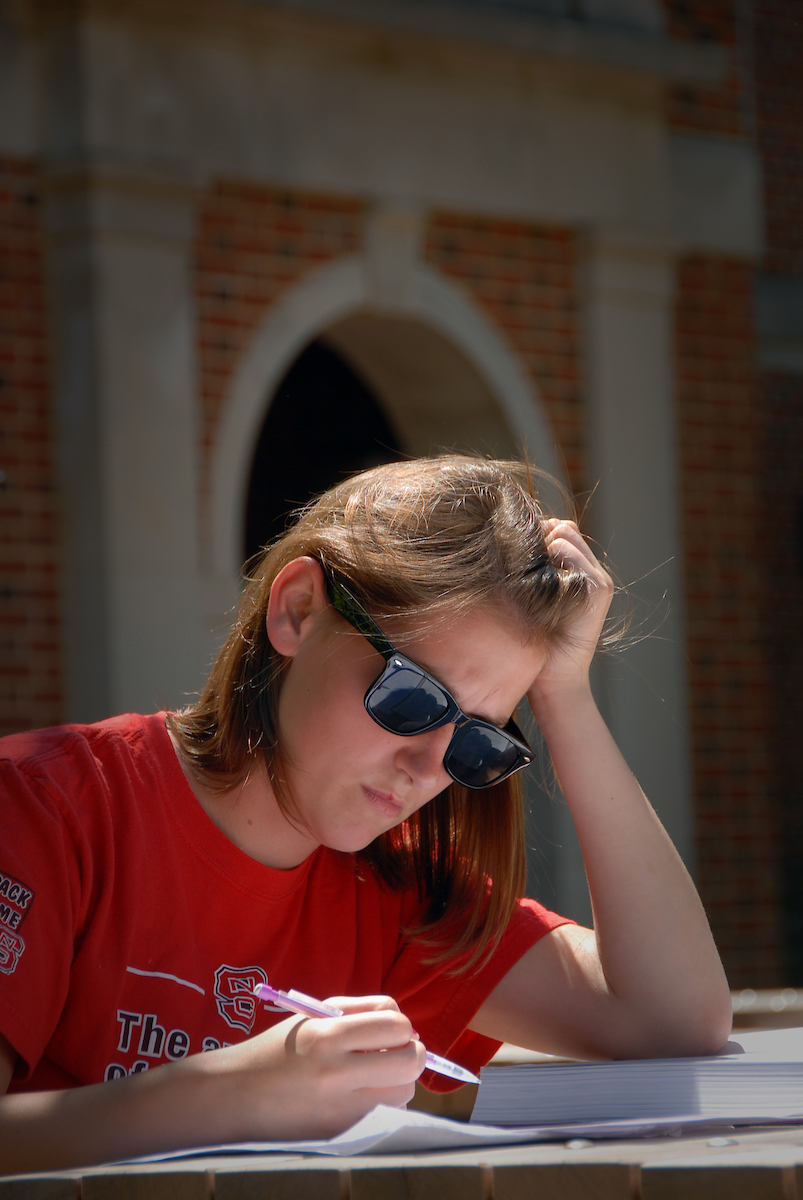 an NC State student studies outdoors