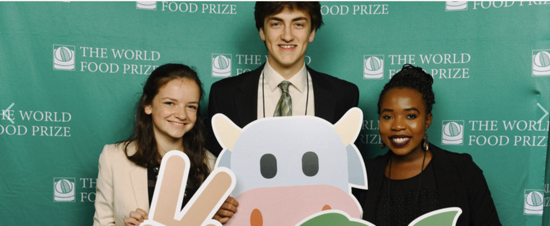 Three students standing in front of a World Food Prize banner