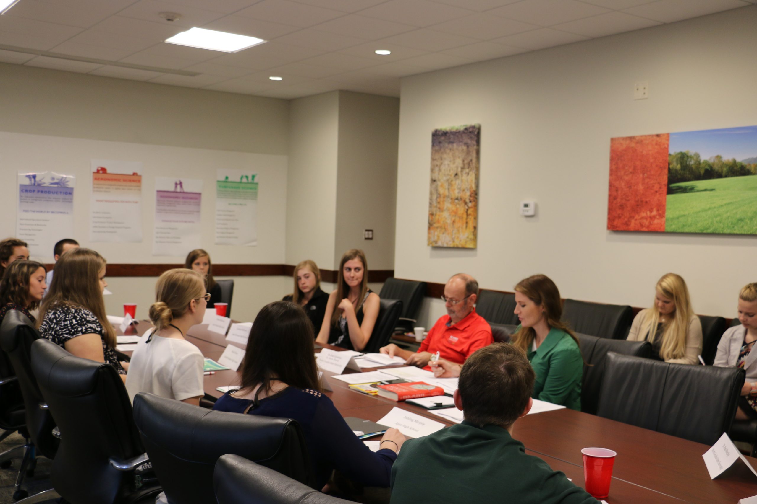 A large group of students seated around a conference table