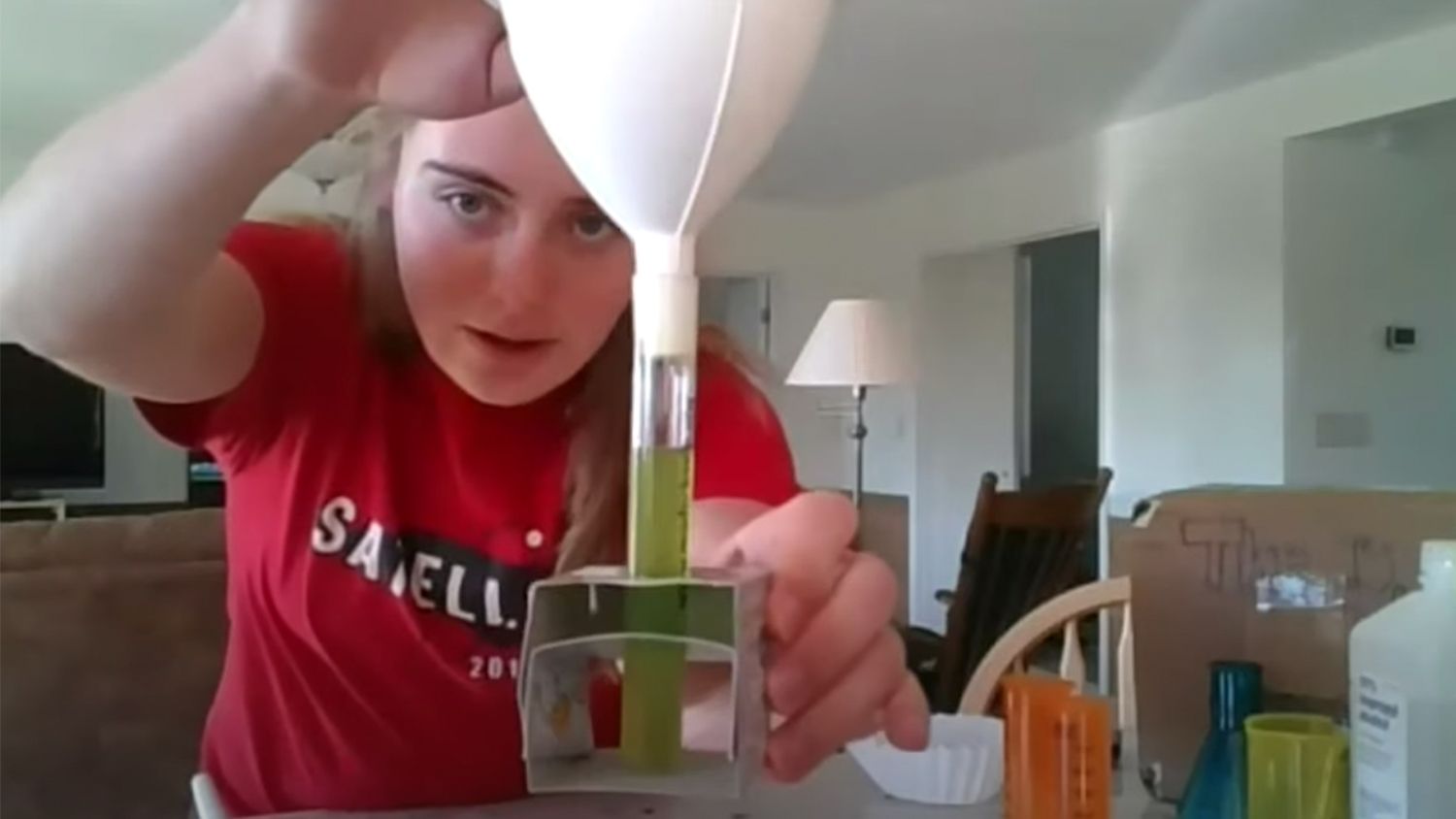 Woman in red shirt performing a test tube experiment
