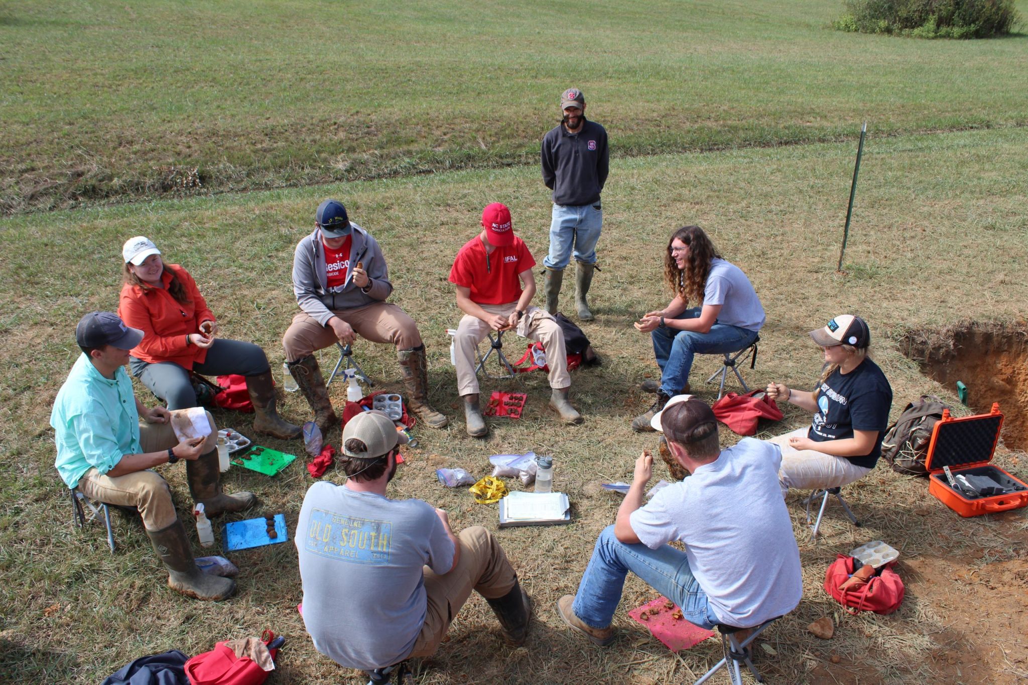 Soil science students sit in a circle outdoors