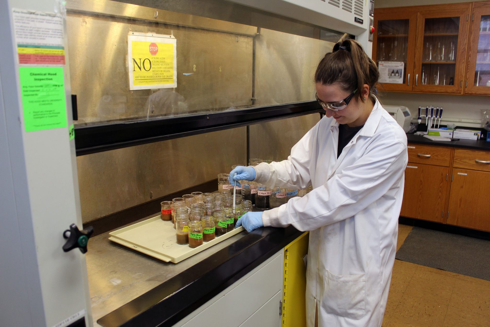 Graduate students measures soil samples in a lab