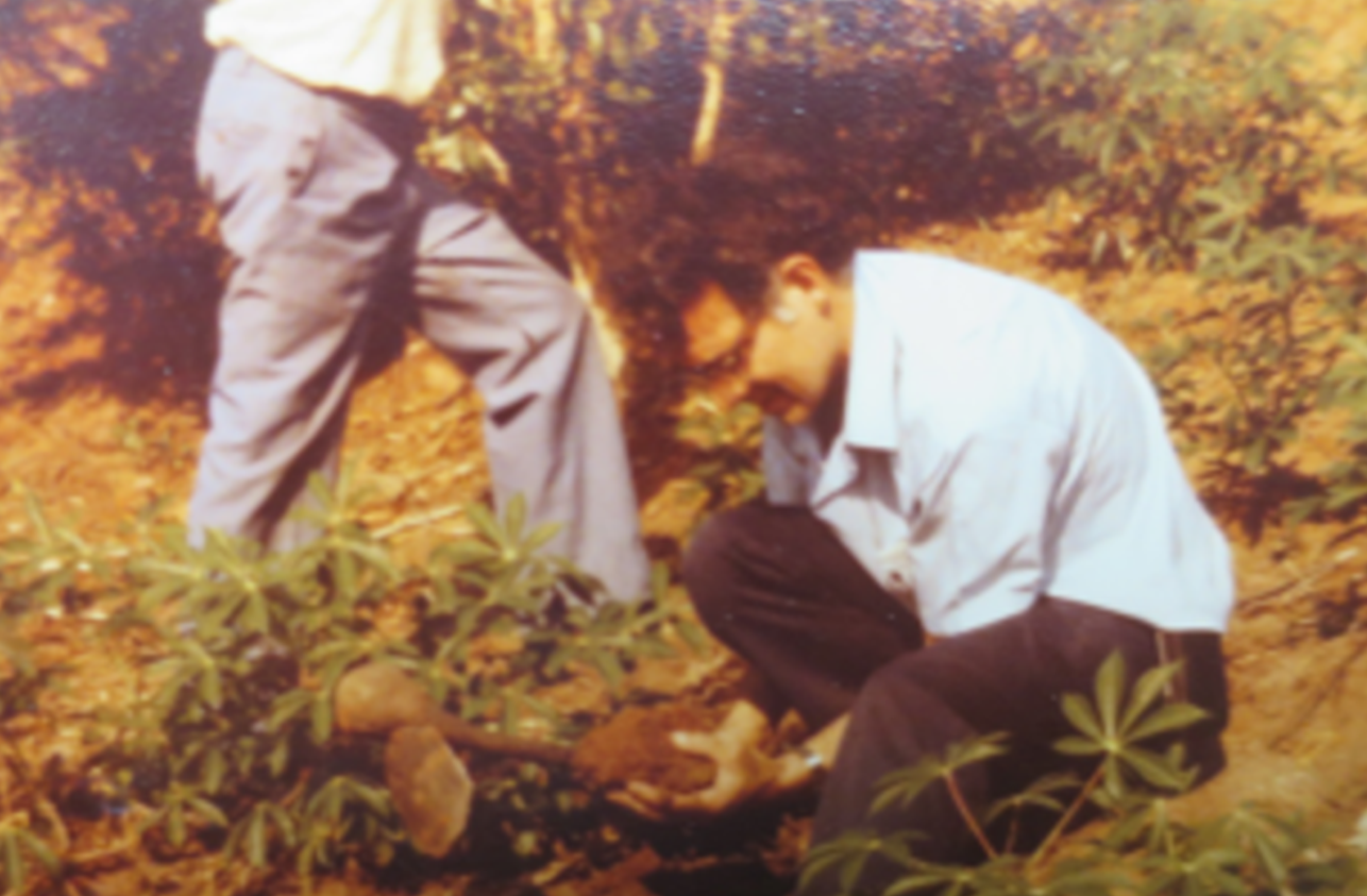 A vintage photo of a young man digging in African soil