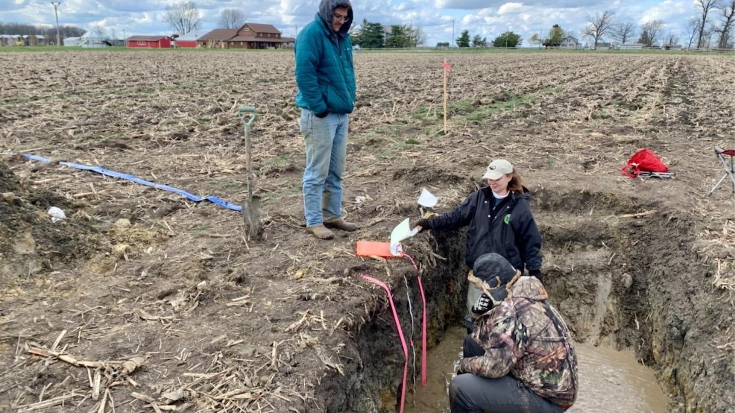 soil judging team members study a profile in cold conditions