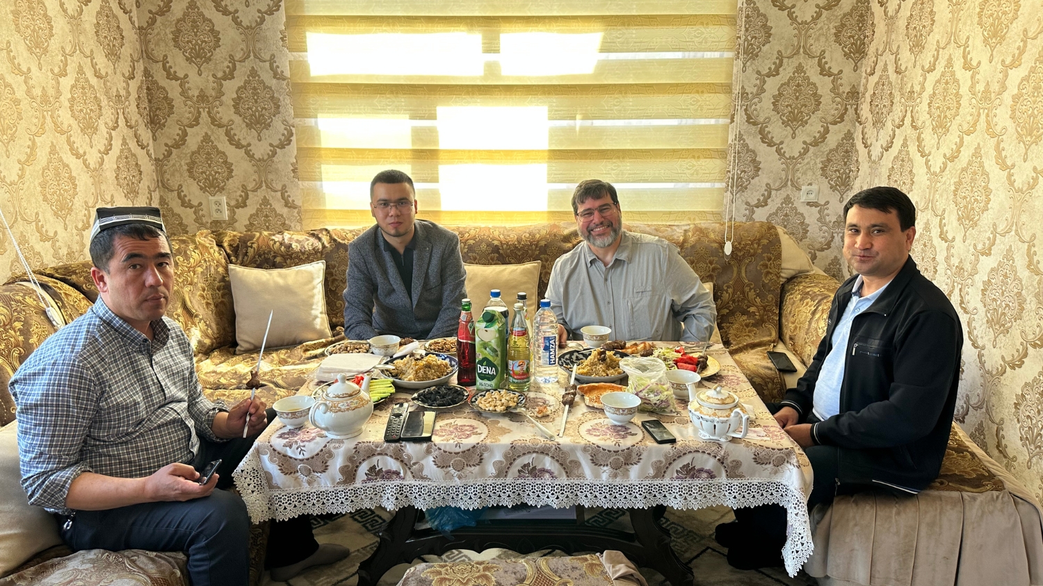 Luke Gatiboni enjoys a meal with Uzbek hosts during his USAID-sponsored visit.