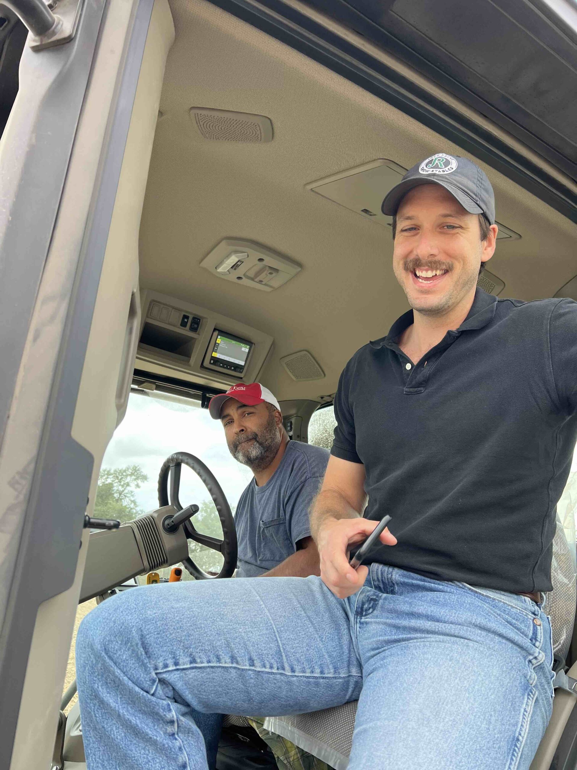 Austin Menker exits the cab of a tractor after riding with a NC farmer to plant cover crops.