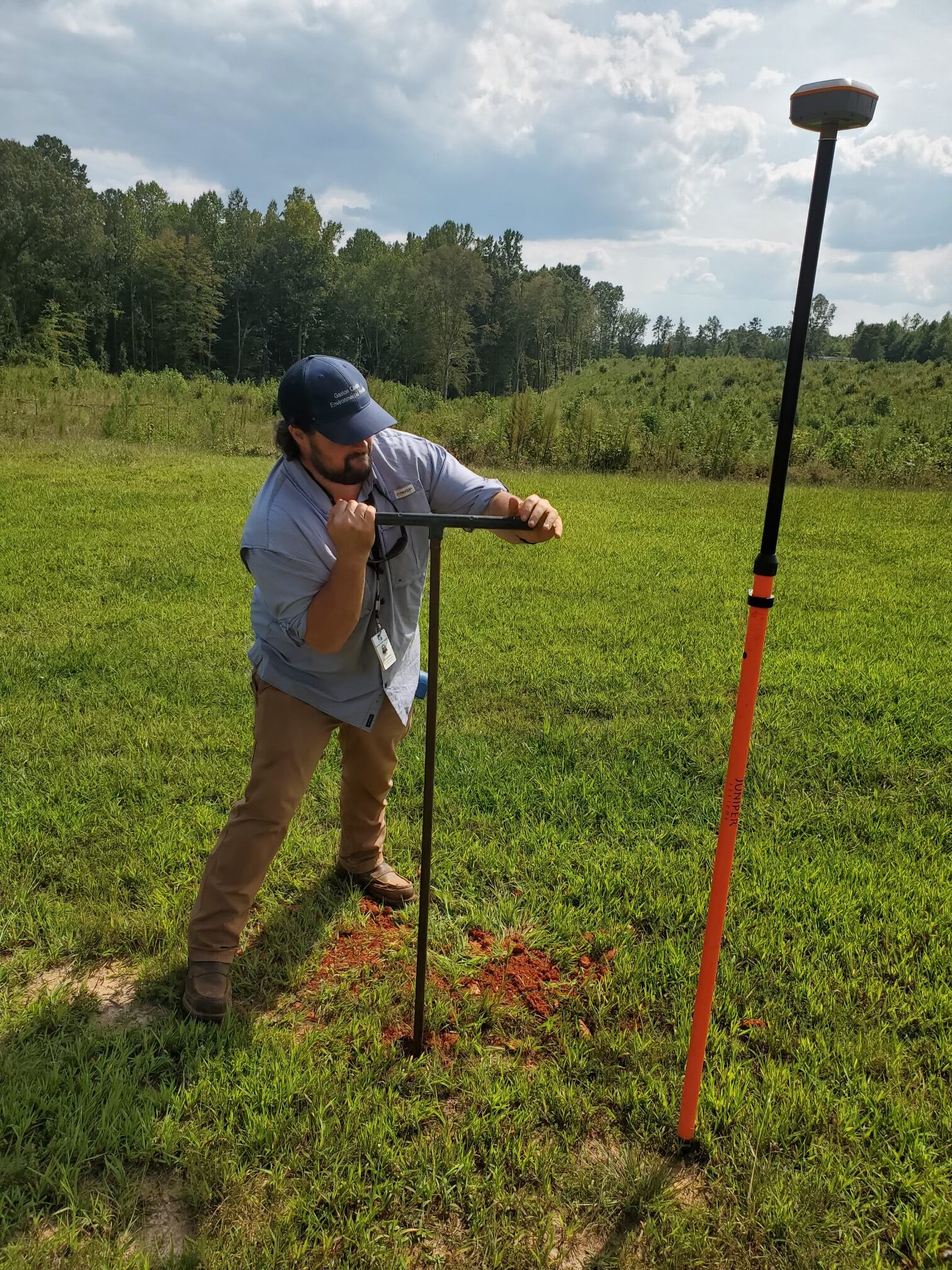 Soil science student Alex McElwee takes a soil core sample.