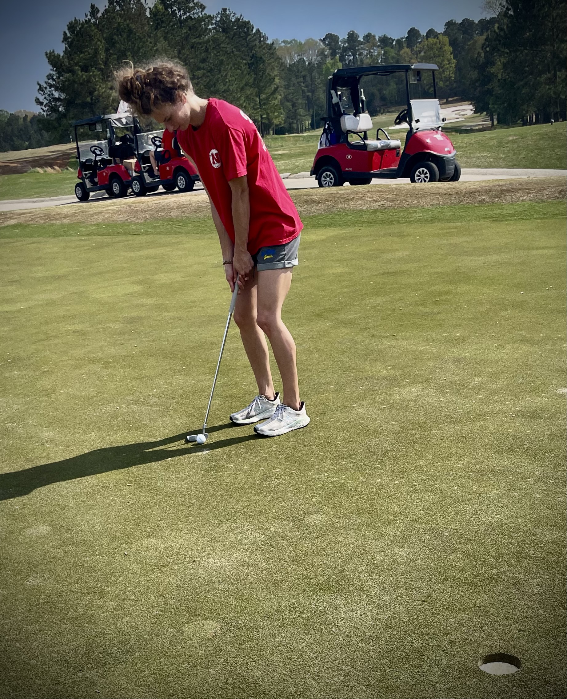 Brynna Bruxellas practices putting at a Grads to Golf event at the Lonnie Poole Golf Course