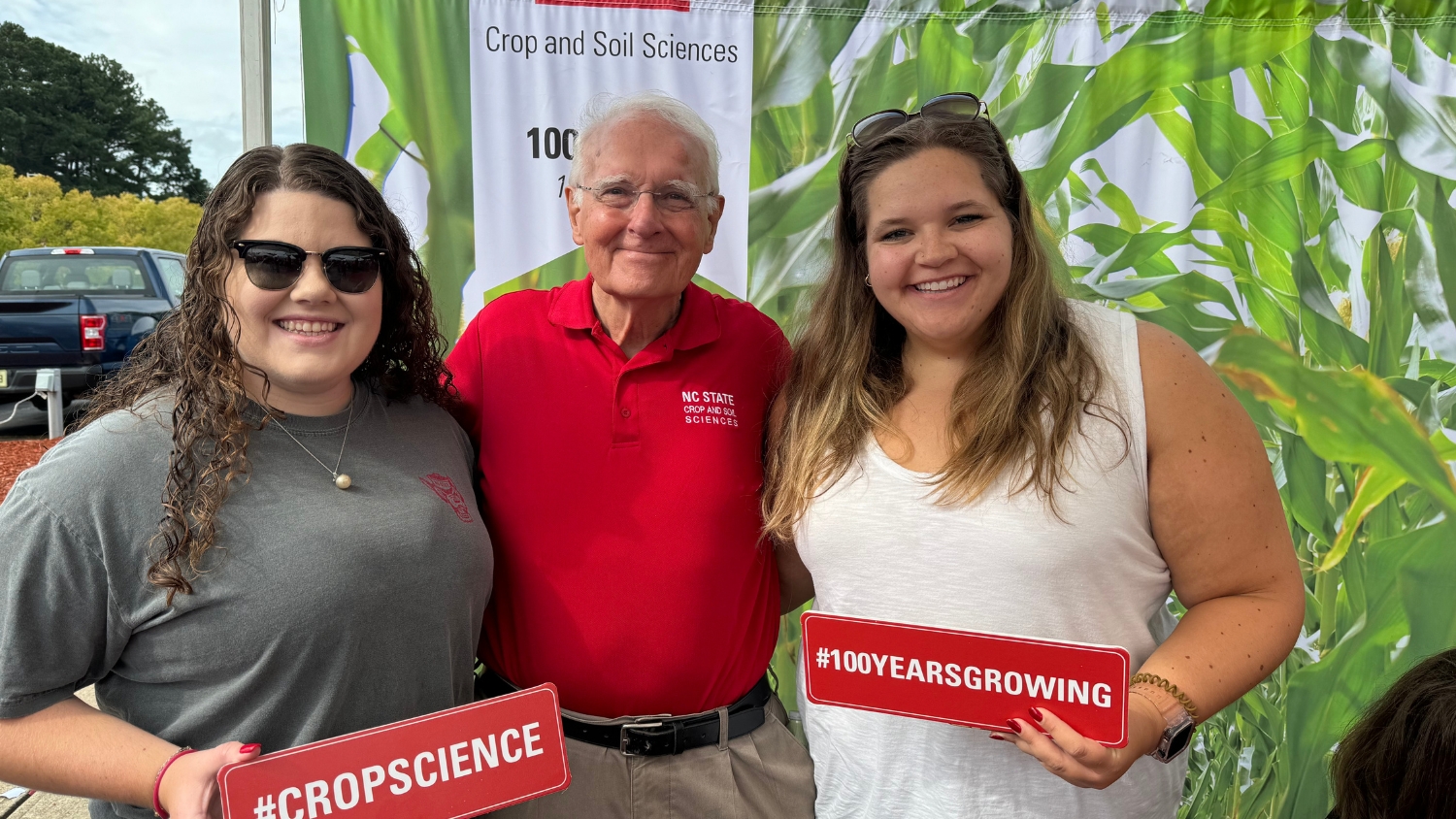 Professor Bob Patterson poses with students at the NC State Crop and Soil Sciences celebration at the 2024 CALS Tailgate.