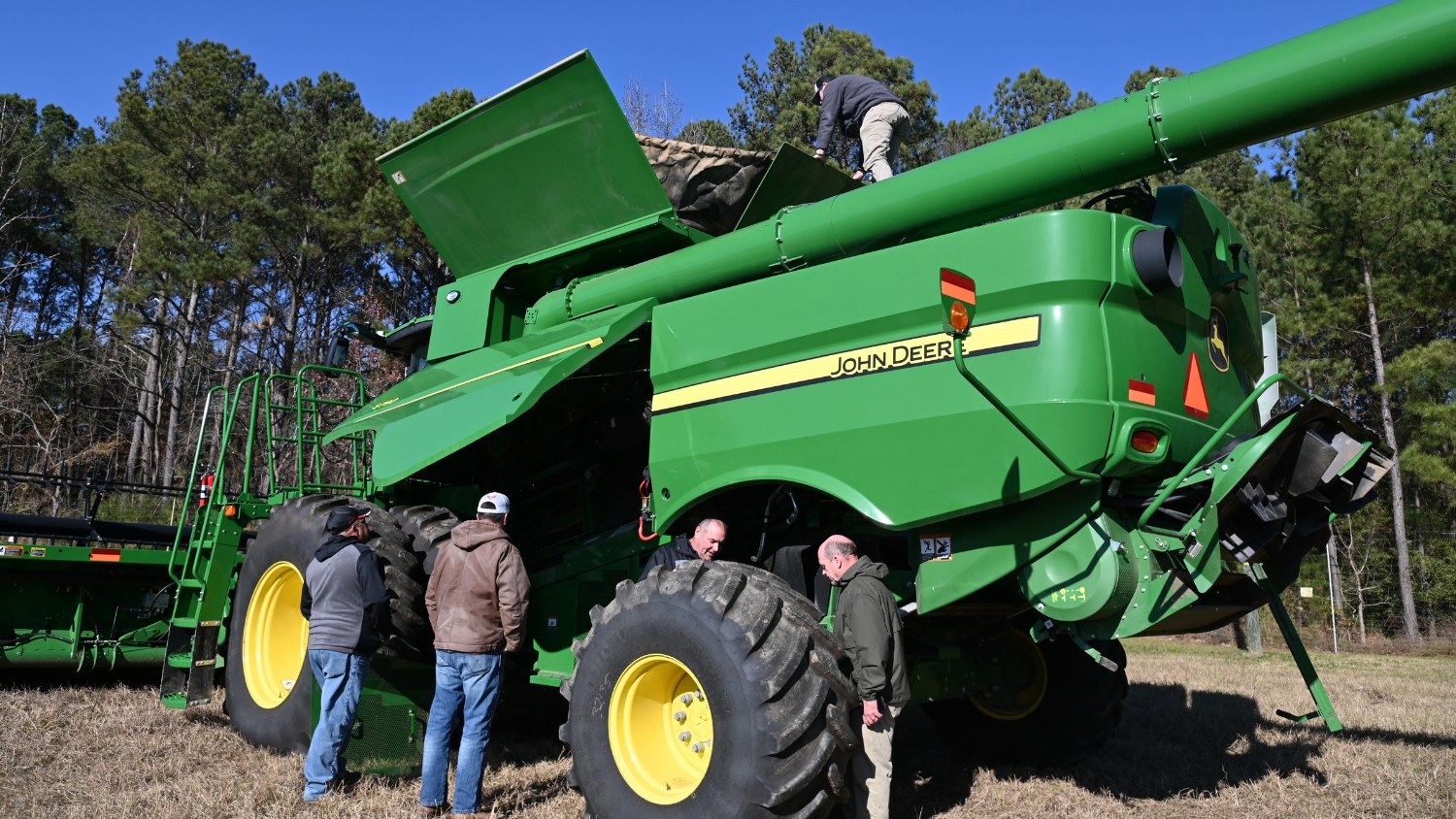 Stephen Swain and extension agents inspect a combine from top to bottom.