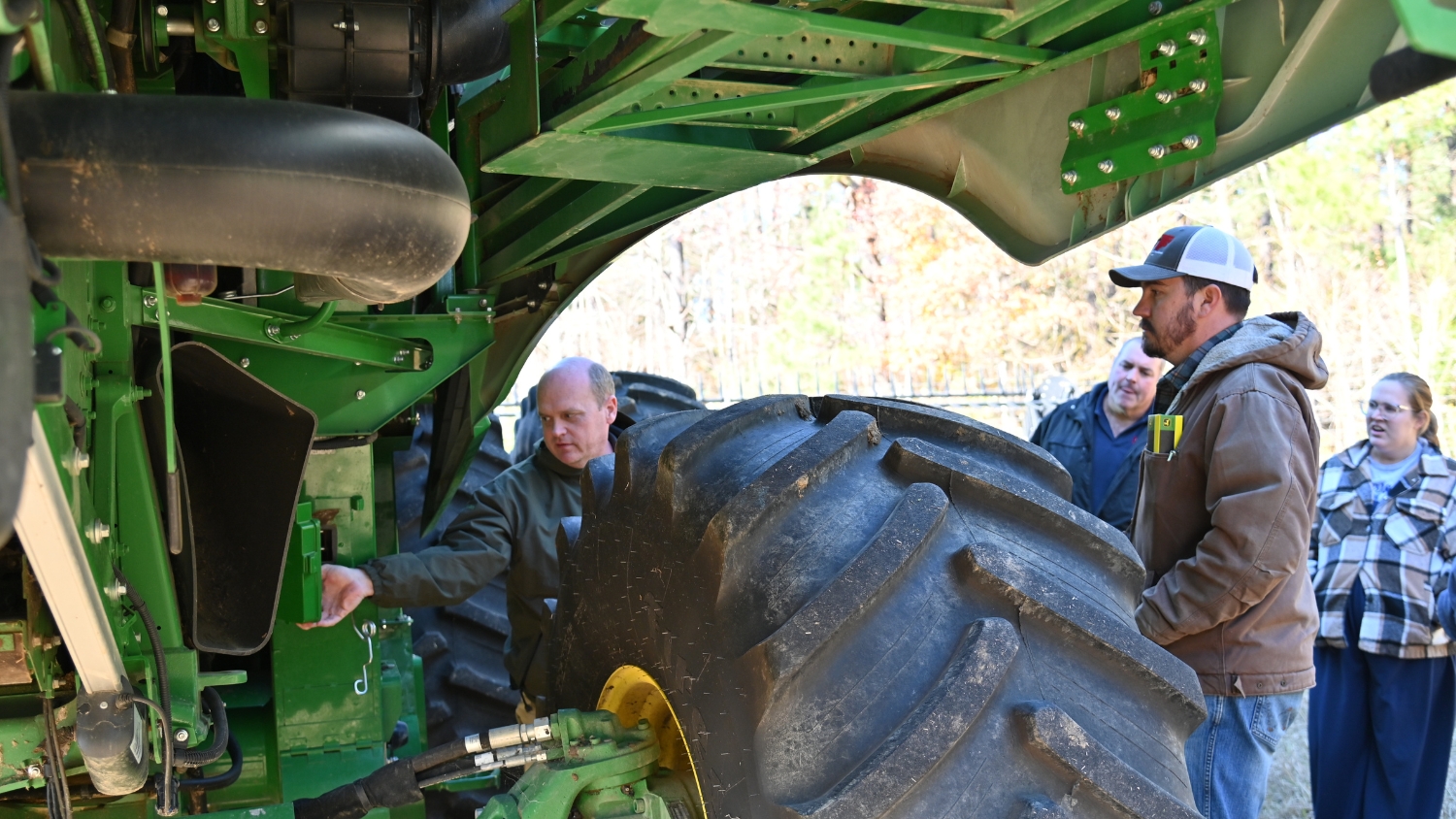 Quality Equipment's Stephen Swain explains a combine's grain camera to a group of NC State Extension agents.