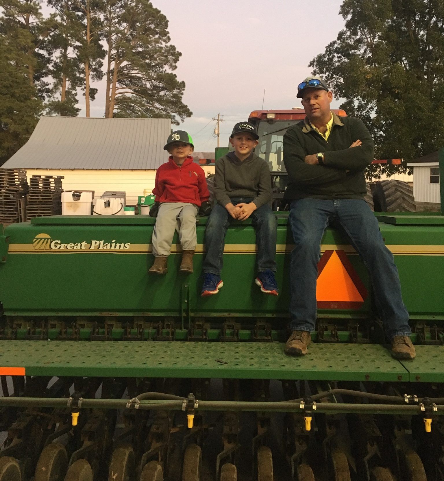 Grandfather and sons sit on a planter