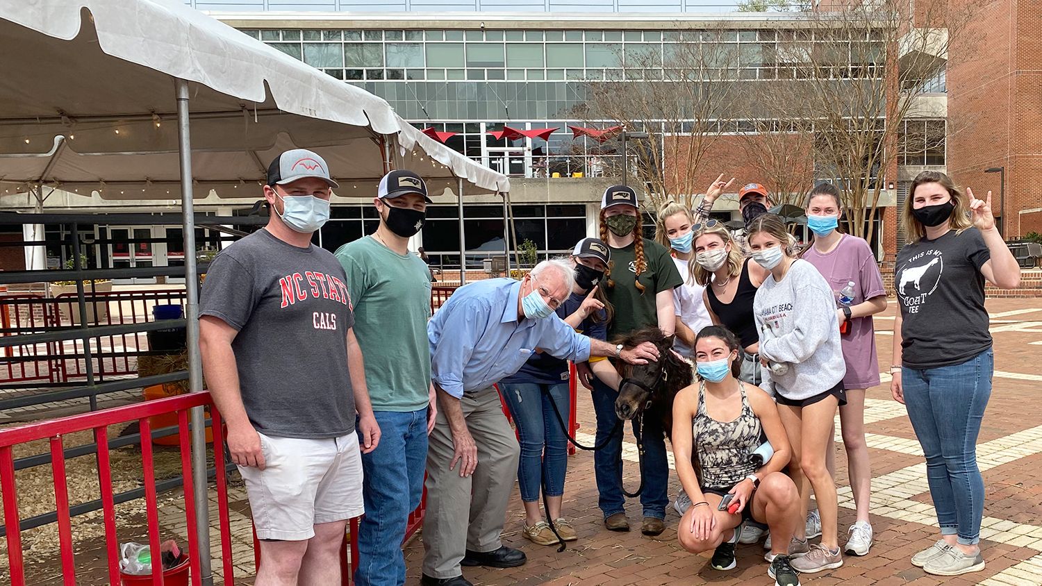 group poses with miniature horse on NC sTate Brickyard