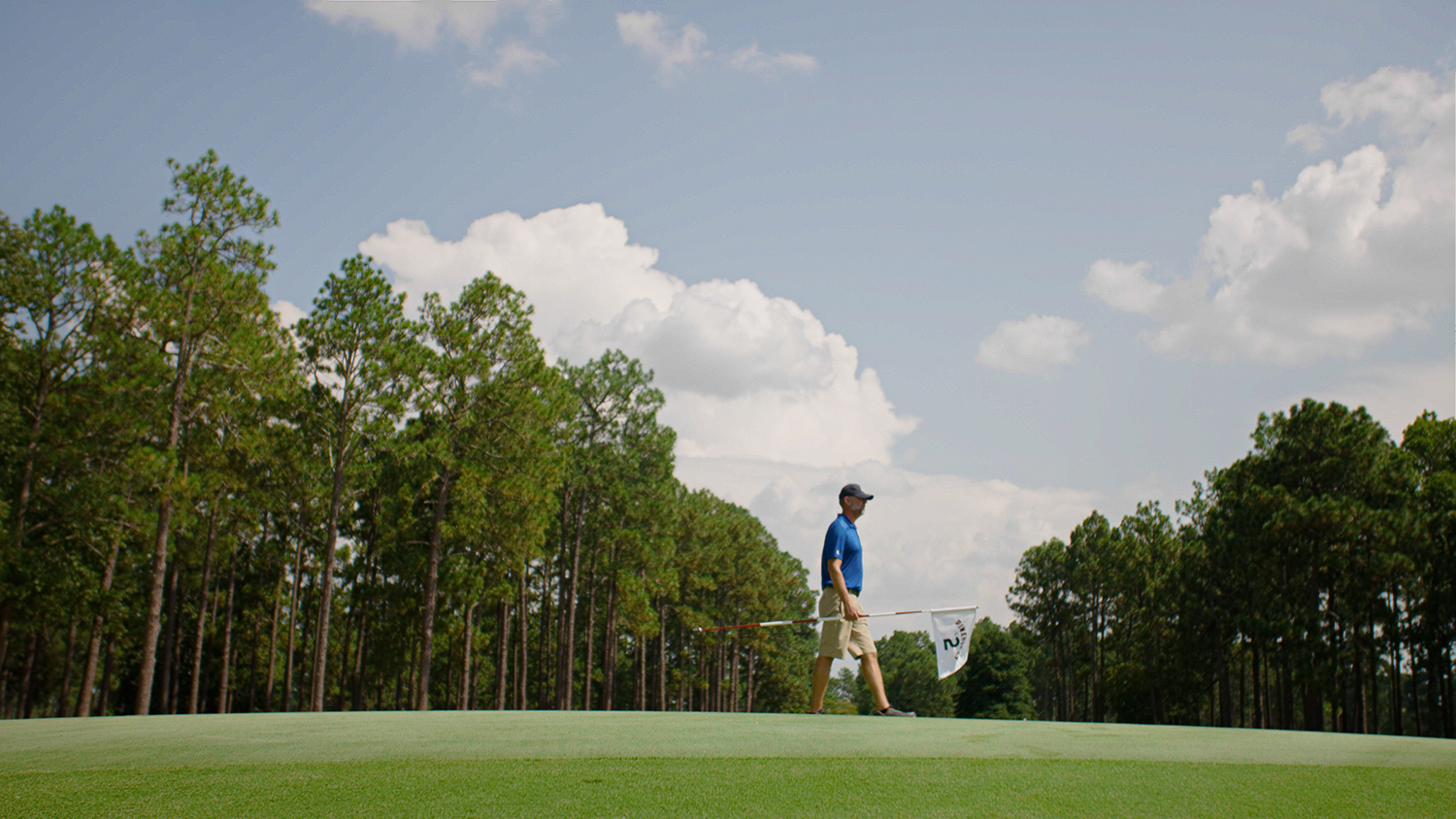 Golf course superintendent walks across a putting green