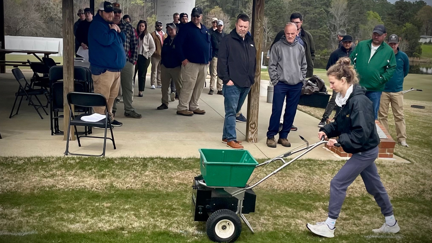 Brynna Bruxellas pushes a spreader at an NC State turfgrass event.
