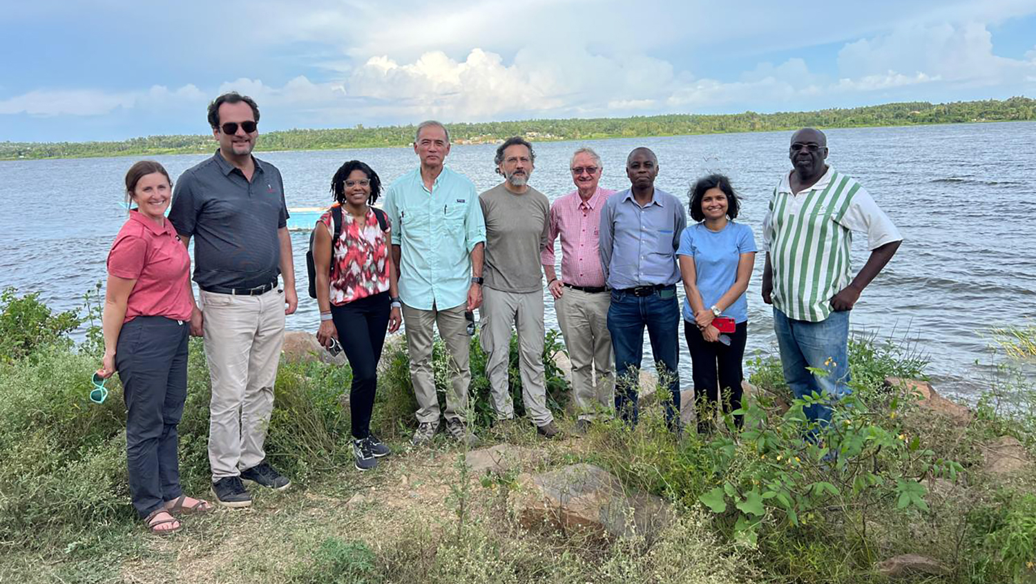 a group of people stand near a river