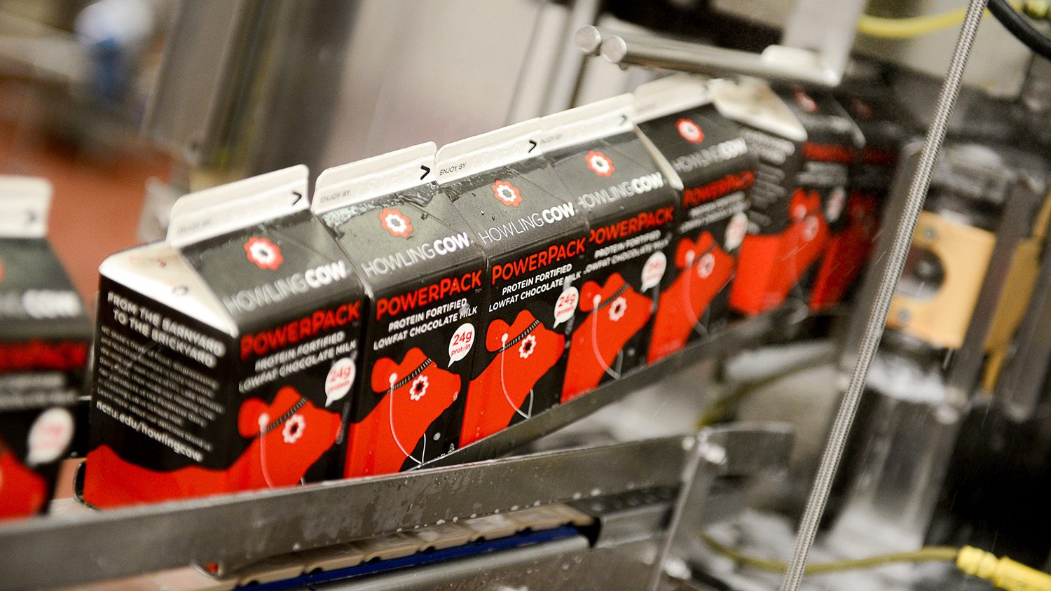 Cartons of PowerPack travel through the packaging process in an NC State food processing facility.