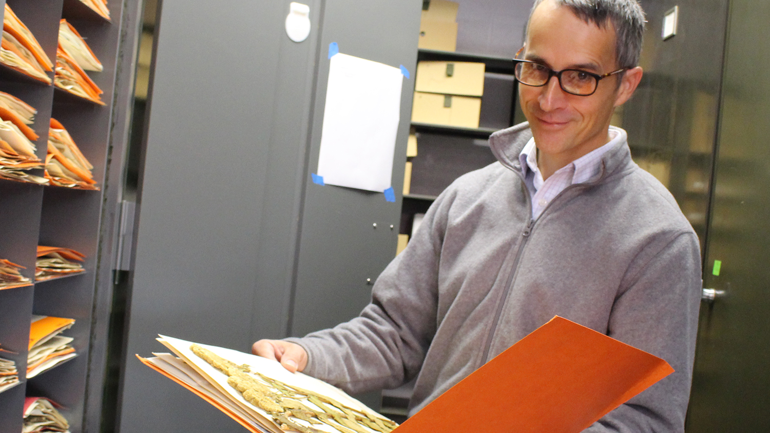 Dr. Alexander Krings holds a folder containing one of the Vascular Plant Herbarium&#039;s plant specimens.