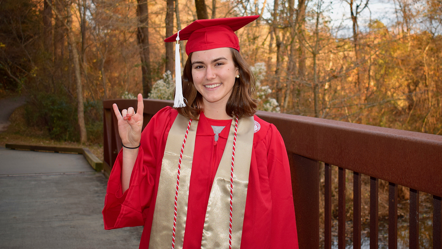 woman in cap and gown with "wolf hands"