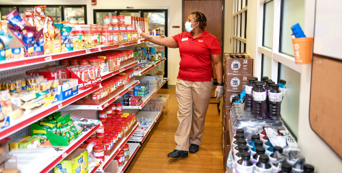 A woman walking through the Feed the Pack pantry.